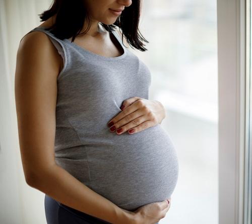pregnant woman with hands around belly